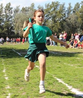 Alumnos corriendo en el campo de deportes